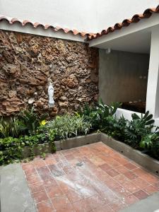 a stone wall with a statue in front of a building at PASANI - Casa de Huéspedes in Bucaramanga