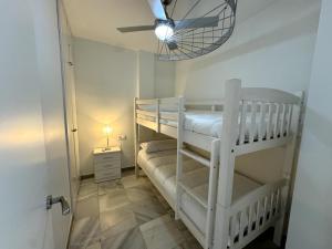 a room with two bunk beds and a ceiling fan at Apartamento Marinas de Nerja in Nerja +32 photos