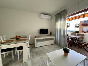 a living room with a dining table and a television at Apartamento Marinas de Nerja in Nerja