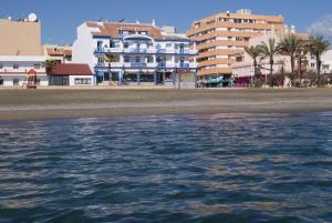 a view of a beach with buildings and the water at Hotel Doña Luisa in San Luis de Sabinillas