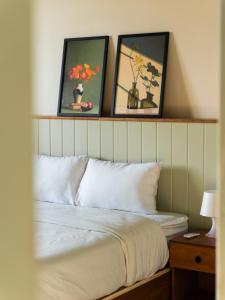 Wujoud - 5 Bedroom Apartment في القاهرة: غرفة نوم بسرير بثلاث صور على الحائط