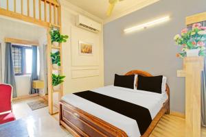 a bedroom with a bed and a red chair at Hotel O Sahasra Residency Near Nexus Hyderabad in Hyderabad