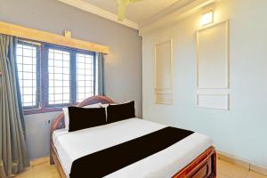 a bedroom with a bed and a window at Hotel O Sahasra Residency Near Nexus Hyderabad in Hyderabad +19 photos