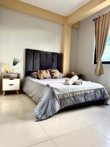 a bedroom with a large bed with a black headboard at Alojamiento Bilbao in Quillacollo