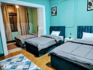 two beds in a room with blue walls at Castle hostel in Cairo