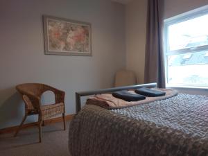a bedroom with a bed and a chair and a window at City Centre A Apartment, 2nd Floor in Belfast