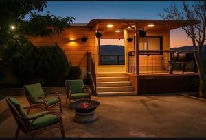 a small house with chairs and a porch at night at צימר אונייל in Majdal Shams