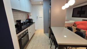 una pequeña cocina con mesa y comedor en Studio Aconchegante Jd Botânico, en Curitiba 7 fotos más