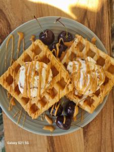 a plate of waffles with ice cream and cherries at Villa by Voila in Mbabane