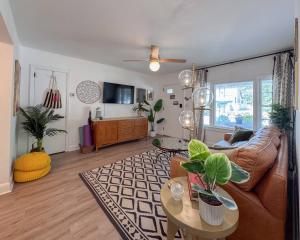 a living room with a couch and a table at HOT TUB + private backyard + riverwalk! in Wilmington