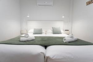 un grand lit blanc avec deux oreillers dessus dans l'établissement TeruelHOME I Con Encanto y parking, à Teruel