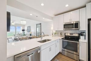 kuchnia z białymi szafkami i jadalnią w obiekcie HP 34W On the Shore by 30A Escapes w mieście Rosemary Beach