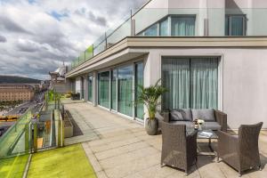 a balcony with a couch and chairs on a building at NH Collection Budapest City Center in Budapest