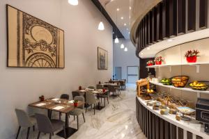 a restaurant with tables and chairs in a room at NH Collection Budapest City Center in Budapest