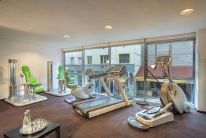 a gym with cardio equipment and a large window at NH Collection Budapest City Center in Budapest