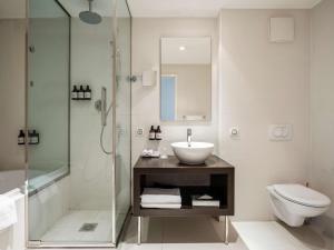 a bathroom with a sink and a shower and a toilet at NH Collection Budapest City Center in Budapest +68 photos