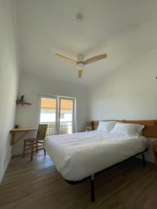a bedroom with a bed with a ceiling fan at Wild Souls Guesthouse in Ericeira