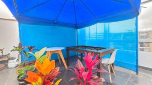 Habitación azul con mesa, sillas y plantas en Dúplex con Terraza en Condominio Los Parques del Callao, en San Antonio