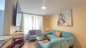 sala de estar con sofá azul y torre eiffel en Dúplex con Terraza en Condominio Los Parques del Callao, en San Antonio