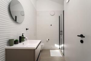 フンタナにあるMediterranee Residenceの洗面台と鏡のある白いバスルーム