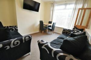 a living room with a couch and a table with chairs at Buckingham Terrace - 4 Bedrooms - Sleeps 7 in Redcar