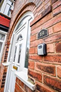 a door of a brick building with a number on it at Buckingham Terrace - 4 Bedrooms - Sleeps 7 in Redcar