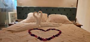 due cigni che fanno un cuore su un letto di Casa Jardim Mar a Anchieta
