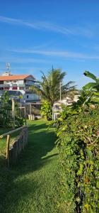 un parco con un edificio, alberi ed erba verde di Casa Jardim Mar a Anchieta