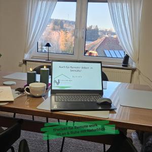 a laptop computer sitting on a table with a window at Ferienwohnungen Schwarzhof -Hanfdell in Nohfelden