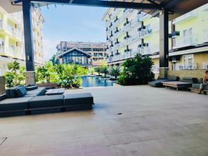 a courtyard in a building with couches and a pool at Amani Grand Resort Residences near Mactan Cebu Intl Airport in Mactan
