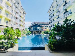 a swimming pool in the middle of two buildings at Amani Grand Resort Residences near Mactan Cebu Intl Airport in Mactan