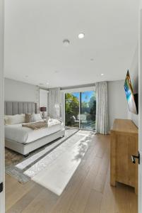 Un dormitorio blanco con una cama y una ventana grande. en Luxury Stay with Pool, Spa, Fire Pit, Outdoor Lounge & Stunning Ocean Views, Encinitas Retreat, en Green Valley Mobile Estates