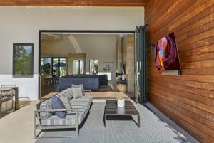 una sala de estar con un sofá y una mesa en Luxury Stay with Pool, Spa, Fire Pit, Outdoor Lounge & Stunning Ocean Views, Encinitas Retreat, en Green Valley Mobile Estates