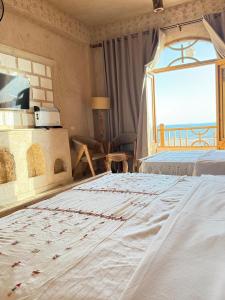 a bedroom with a large bed and a window at Breezy island Hotel in Siwa