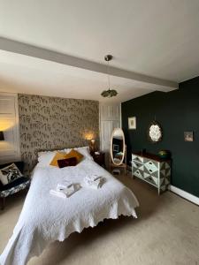 a bedroom with a large bed and a chair at Three private rooms in the Master Suite, Cotswolds Coaching Inn - Traveller Awards Winner 2026 in Naunton