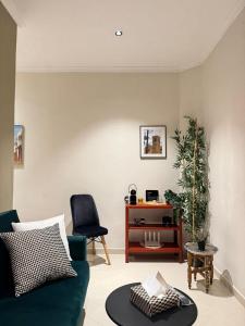 uma sala de estar com um sofá verde e uma mesa em Cozy Flat Heart of Medina Tetouan em Tetouan