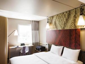 a hotel room with a bed and a desk at ibis Winterthur City in Winterthur +113 photos