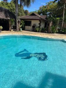 un homme debout dans l'eau d'une piscine dans l'établissement Pebs one bedroom apartment, à Mombasa