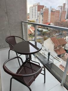 a table and chair on a balcony with a view at Mono 611 in Neuquén