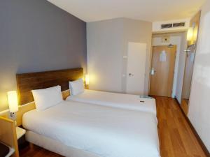 a bedroom with a large white bed with two pillows at Ibis Bratislava Centrum in Bratislava +61 photos