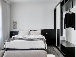 a black and white bedroom with a bed and a closet at Mercure Belo Horizonte Lourdes in Belo Horizonte