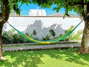 una hamaca colgando entre dos árboles en un patio en Casa Temporada Ubatuba próxima à praia, check-in e out flexíveis com 5 vagas na garagem, wifi, en Ubatuba 41 fotos más