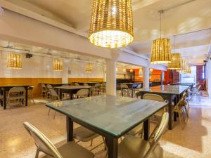 a dining room with tables and chairs and chandeliers at Oaxaca Guest Hotel in Oaxaca City
