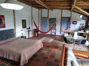 a bedroom with a bed and a table in a room at HOSTAL CASA DE GUADUA/ THE BAMBOO HOUSE in Choachí