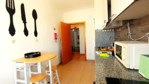una cucina con tavolo e utensili appesi al muro di Gardunha Apartments Avenida V a Fundão Altre 21 foto