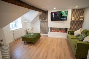 a living room with a green couch and a fireplace at Sea Donard Apartment, Newcastle in Newcastle