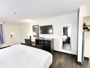 a hotel room with a large bed and a tv at Baymont by Wyndham Tallahassee in Tallahassee