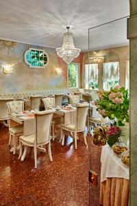 a dining room with tables and chairs and a chandelier at Hotel Gardena in Venice