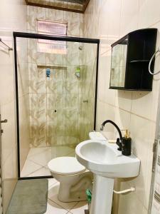 a bathroom with a toilet and a sink and a shower at Meu aconchego - check-in e checkout flexível in Belém