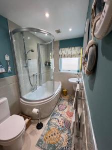 a bathroom with a tub and a toilet and a sink at Lighthouse Cottage Cullen in Cullen